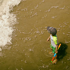 A young boy at the Coney Island Beach with a Super Soaker